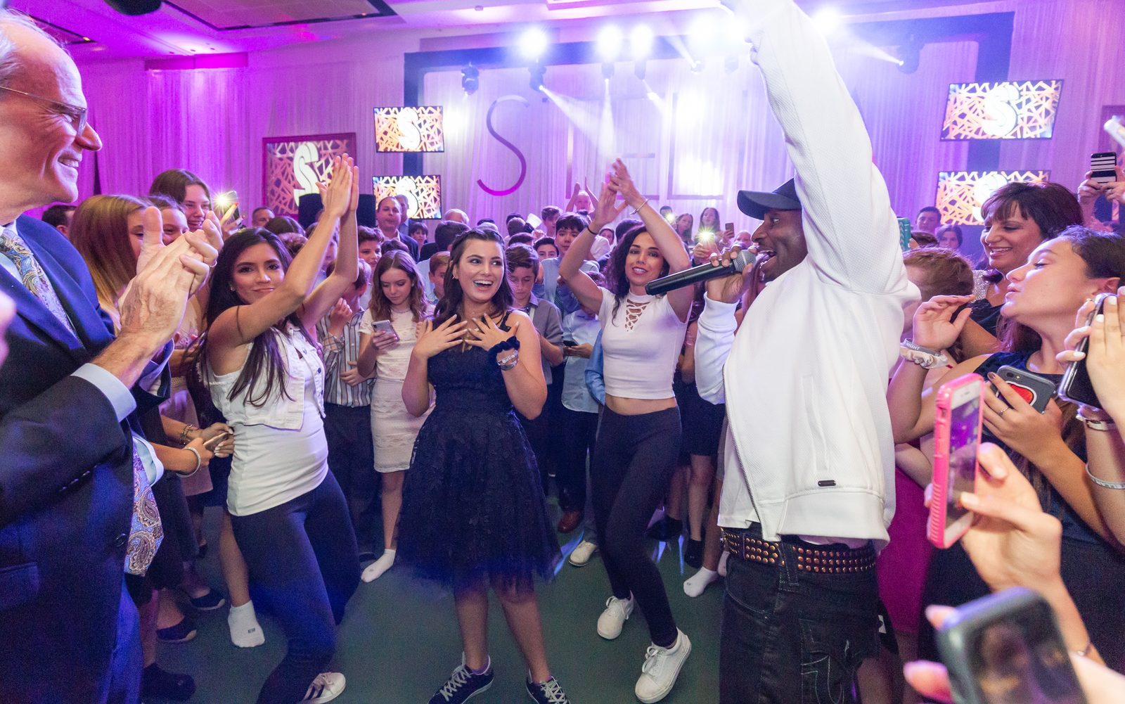 Guests with hands raised on the dance floor