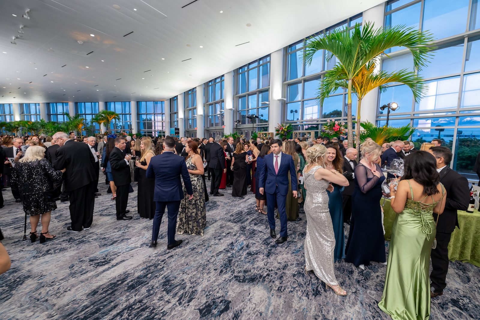 Guests mingling in a waterfront ballroom at a corporate gala