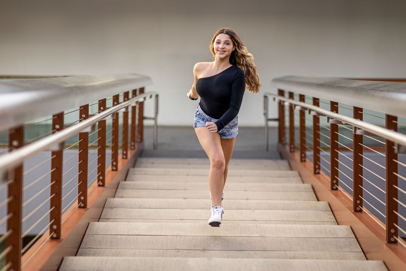 Girl walking across a wooden boardwalk bridge