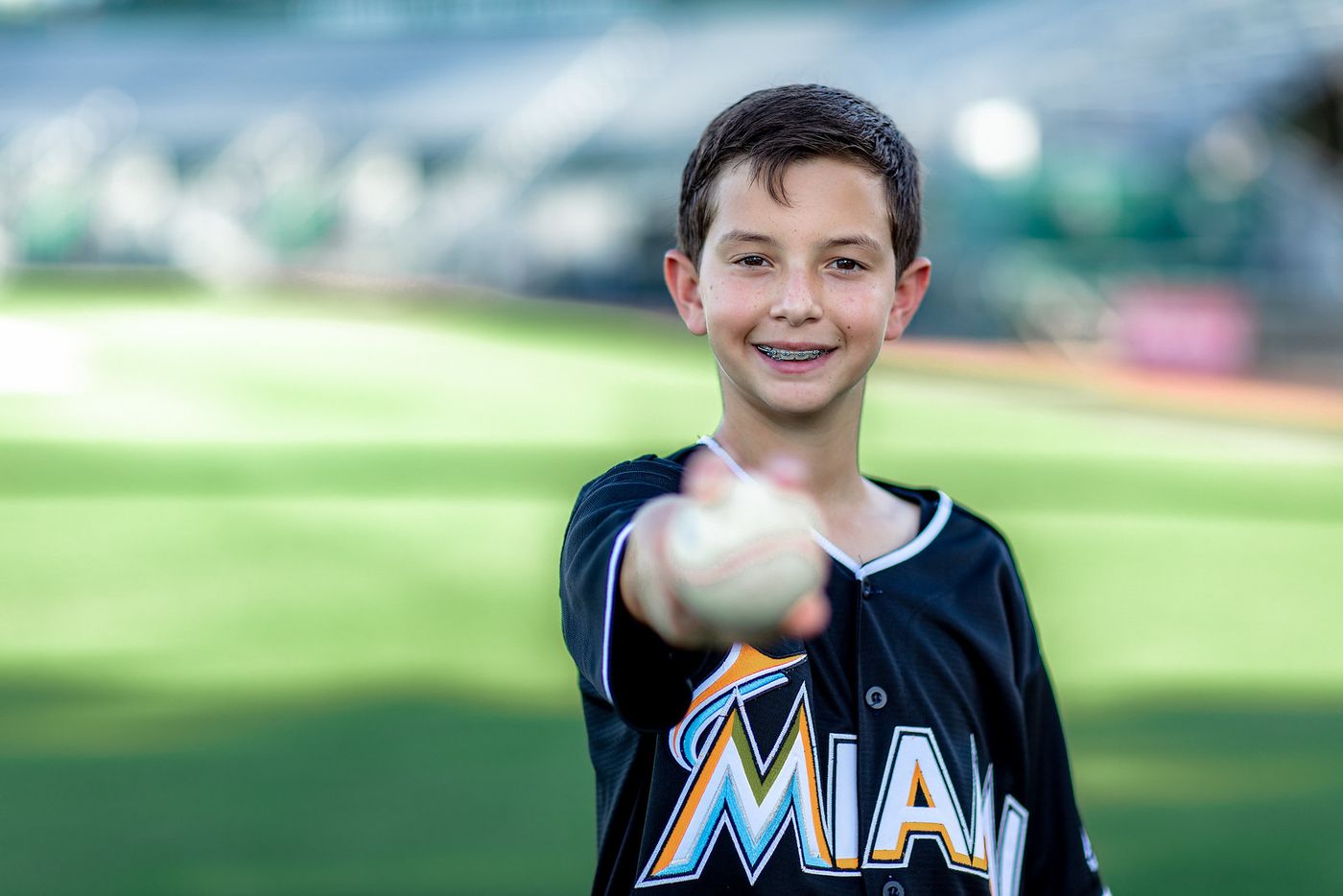 Boy pitching a baseball on a Miami baseball field