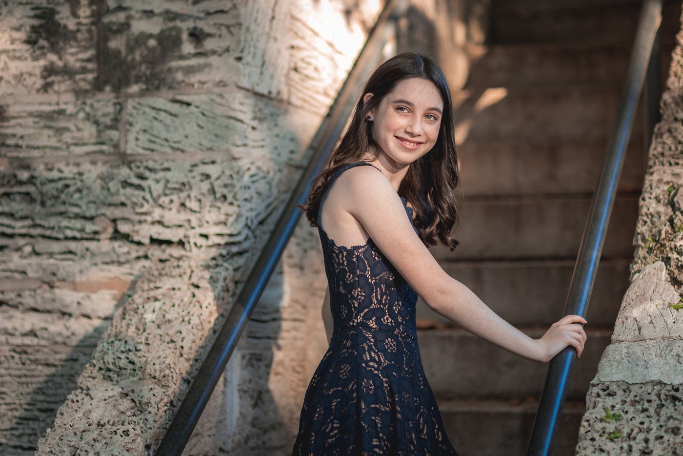 Girl in a black dress on an ornate staircase