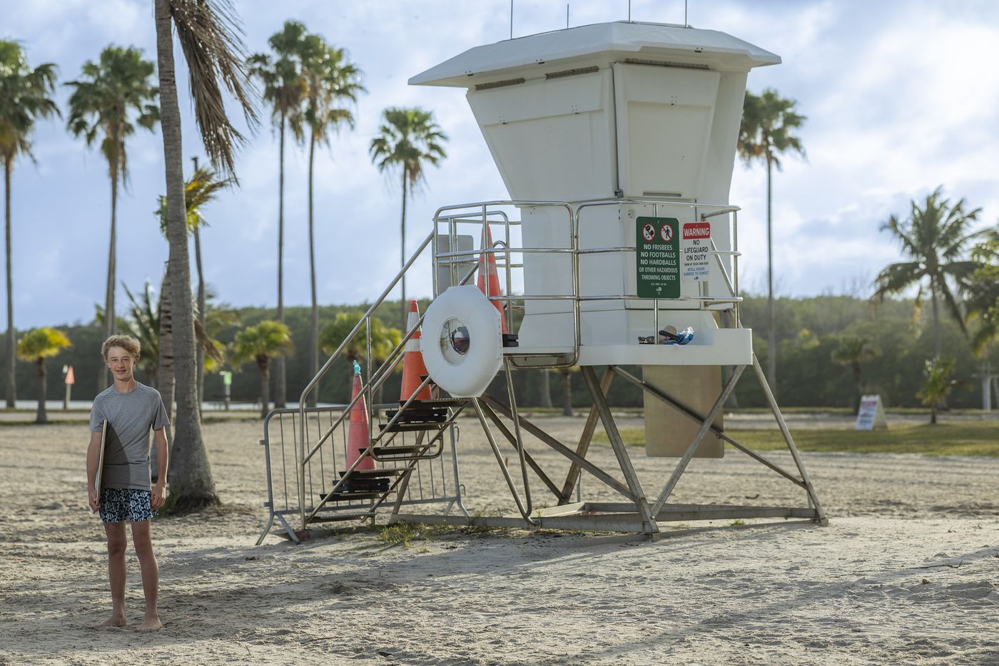 Girl walking the beach near a lifeguard stand