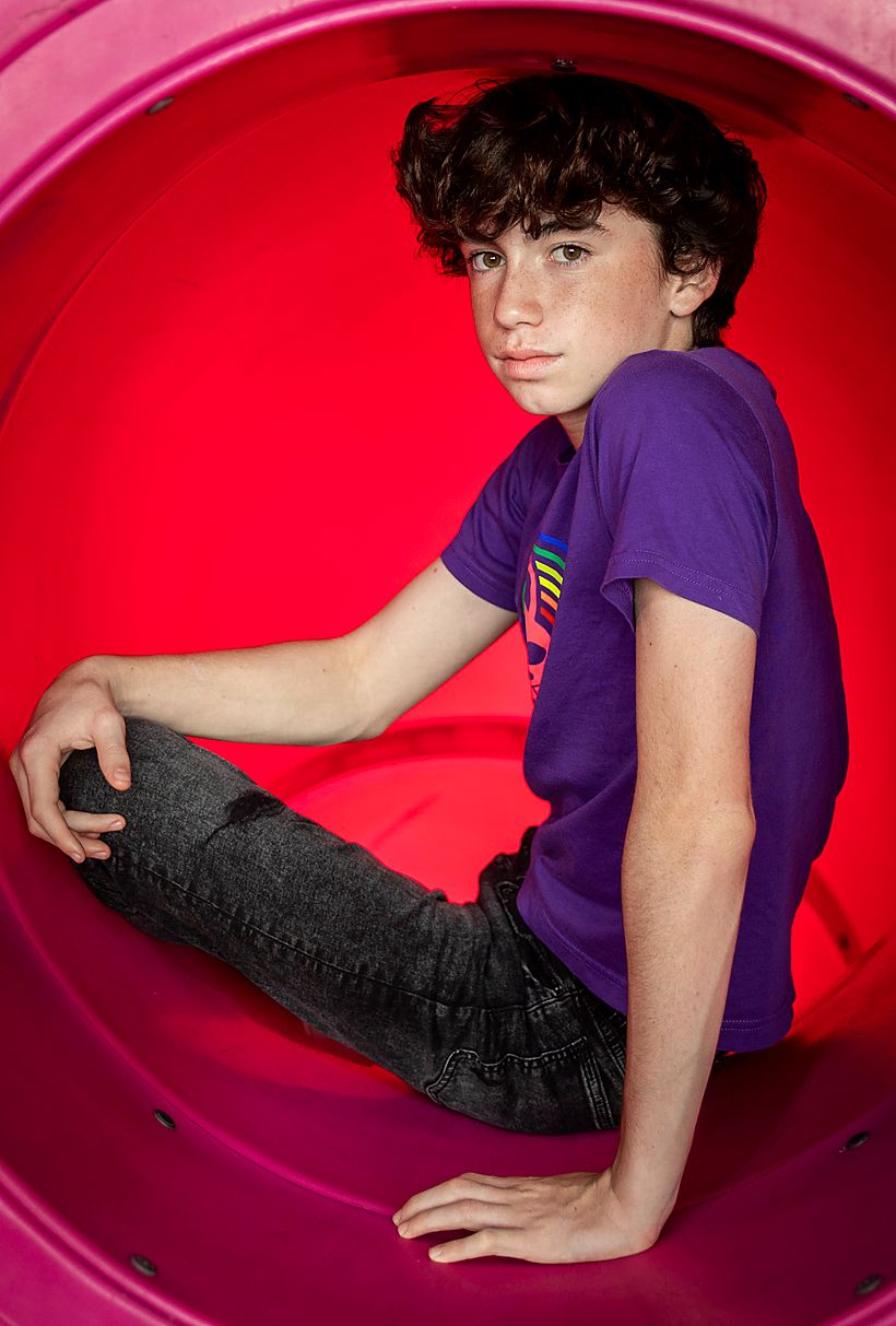 Boy seated inside a red circular sculpture