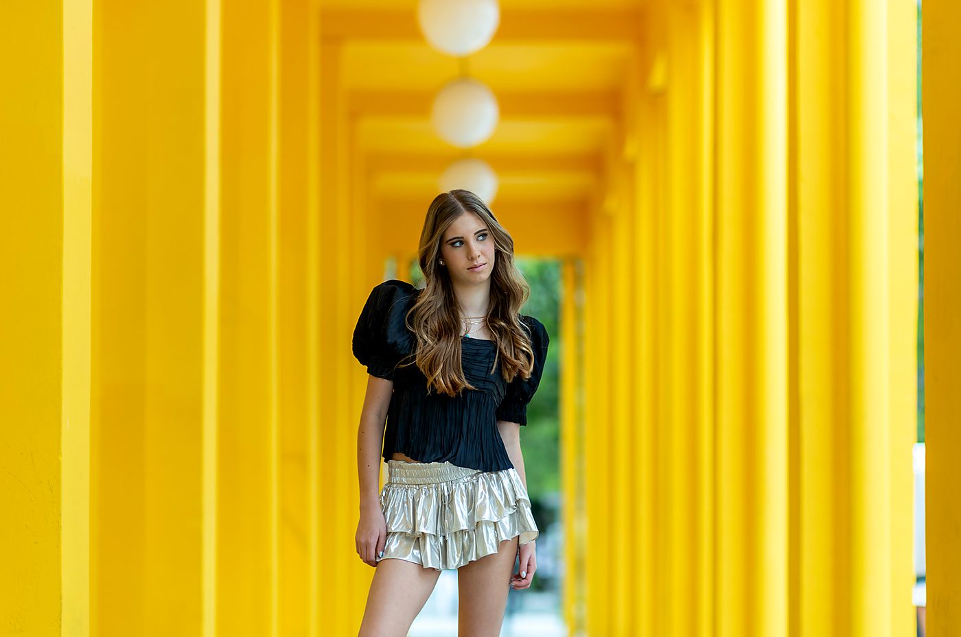 Girl in a yellow slatted corridor in the Miami Design District
