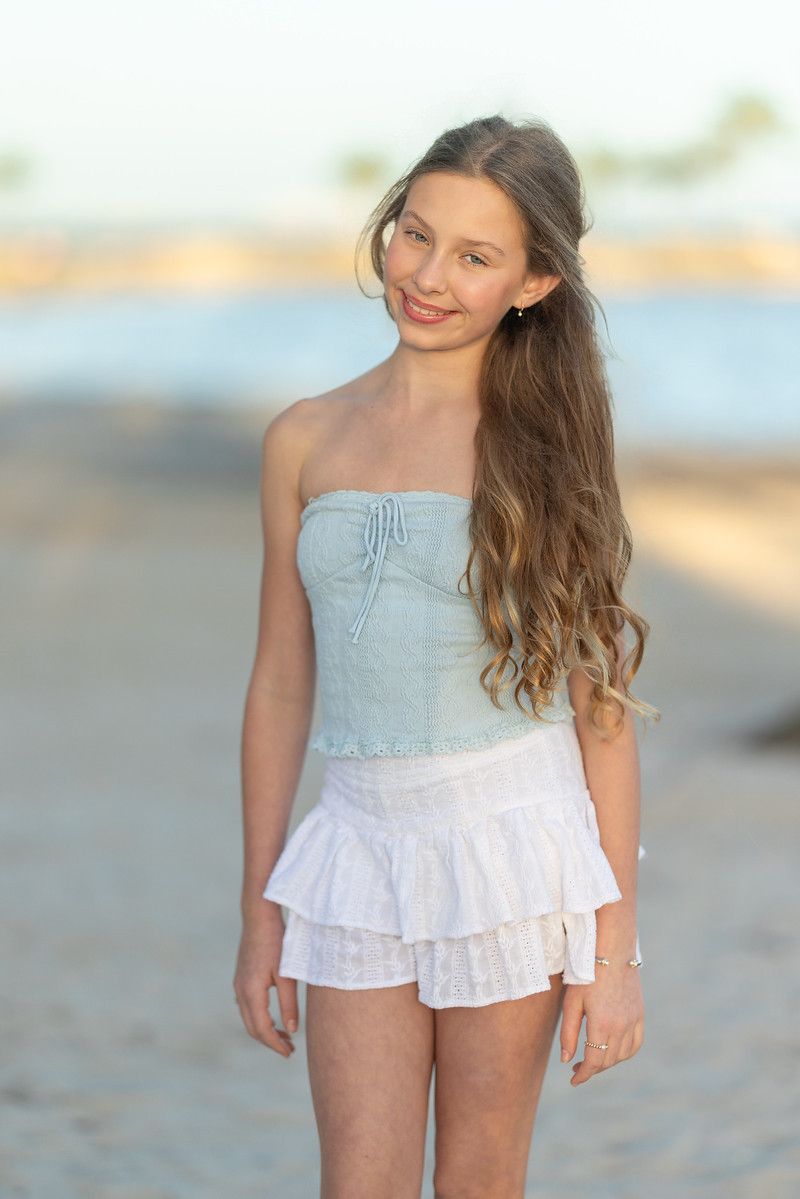 Girl in a white dress standing by the water